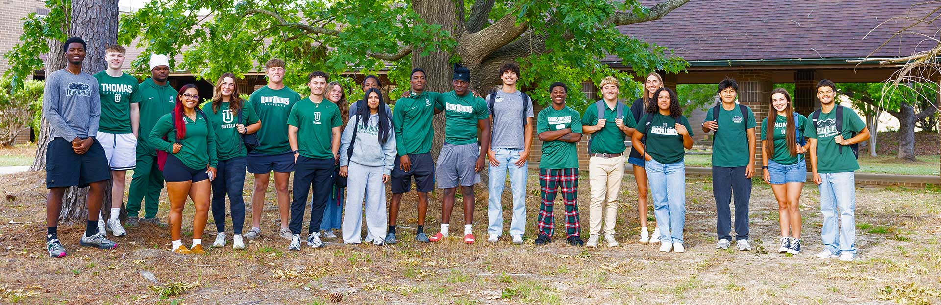 A large group of students in front of a large tree on Thomas University's new Woodlands Campus